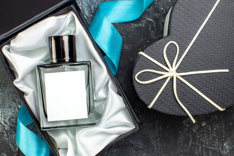 above view of blue ribbon on man perfume in a gift box and beautiful gift box on dark scaled 1 - CADERNO DE MODA